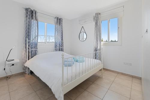 a white bedroom with a white bed and windows at Glabur Stays - The Sunny Atelier - Nicosia City, Free Parking & Wifi, Welcomes You!!! in Nicosia