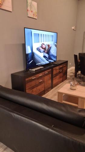 a living room with a flat screen tv on a dresser at Flensburg City - 24h in Flensburg