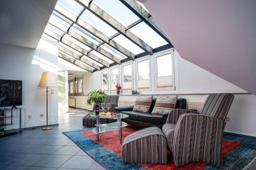 un soggiorno con divani e soffitto in vetro di Hotel am Stadtpark a Hilden