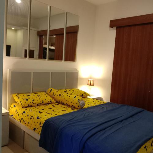 a bedroom with a bed with yellow sheets and pillows at bintang room in Bekasi