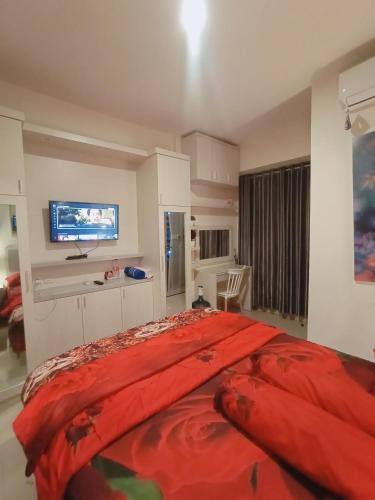 a bedroom with a large bed with a red blanket at bintang room in Bekasi