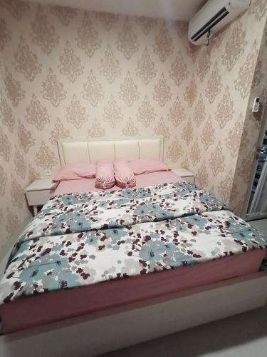 a bedroom with a bed with a pink and blue comforter at bintang room in Bekasi