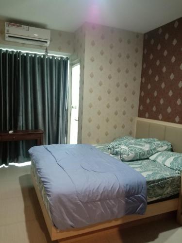 a bedroom with a bed with blue sheets and a window at bintang room in Bekasi