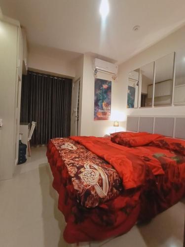 a bedroom with a bed with a red blanket at bintang room in Bekasi