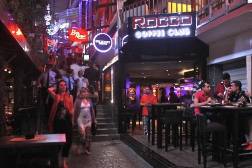 a group of people walking in a bar at night at St Julians Bay Sea Front Apartments in St Julian's