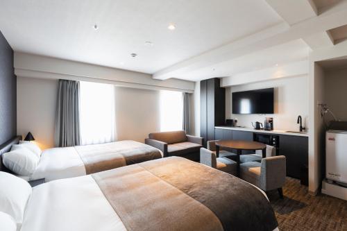 a hotel room with two beds and a television at HOTEL ASYL TOKYO KAMATA in Tokyo