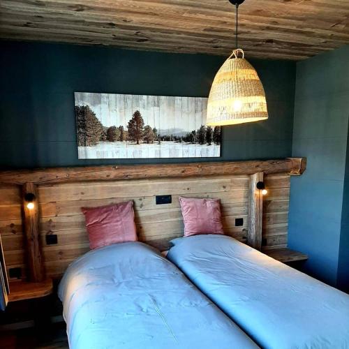 a bedroom with a bed with blue sheets and pink pillows at Renée Cense in Houffalize