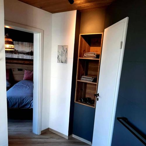 a bedroom with a bed and an open door at Renée Cense in Houffalize