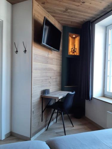 a room with a desk and a tv on a wall at Renée Cense in Houffalize