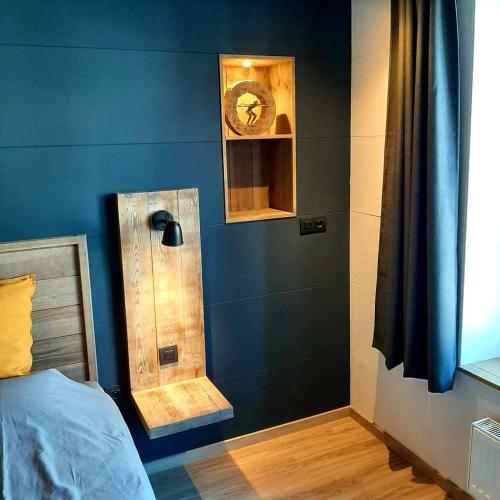 a bedroom with a blue wall with a clock on the wall at Renée Cense in Houffalize