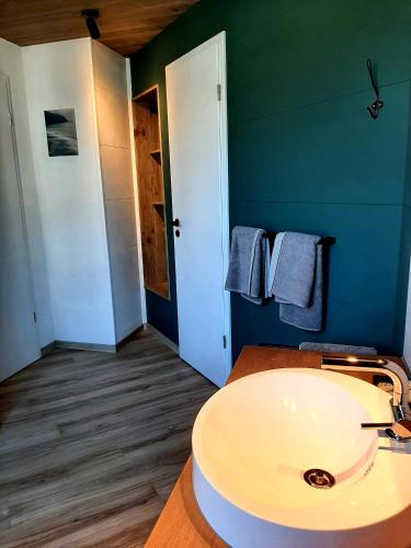 a bathroom with a sink and a blue wall at Renée Cense in Houffalize
