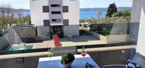 a table with two glasses of wine on a balcony at Villa Ivan in Sveti Filip i Jakov