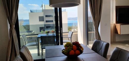 a dining room table with a bowl of fruit on it at Villa Ivan in Sveti Filip i Jakov