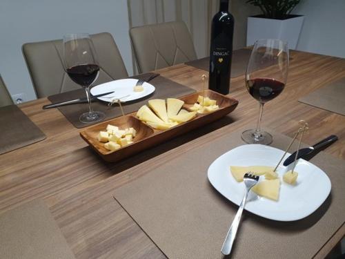 a table with glasses of wine and a tray of cheese at Villa Ivan in Sveti Filip i Jakov