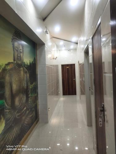 a large painting of a statue on a wall in a hallway at Jasneet Homestay in Amritsar