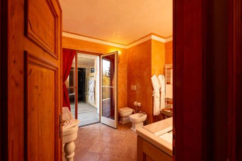 a bathroom with a toilet and a tub and a sink at Villa Orso Grigio in Ronzone
