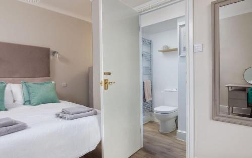 - une chambre avec un lit et une salle de bains avec des toilettes dans l'établissement Gorgeous cottage by sandy beach Dog friendly, à Port Erin