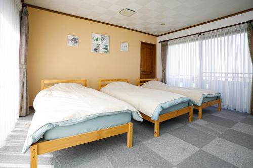 dwa łóżka siedzące obok siebie w pokoju w obiekcie Gairoju / Vacation STAY 2366 w mieście Higashi-osaka