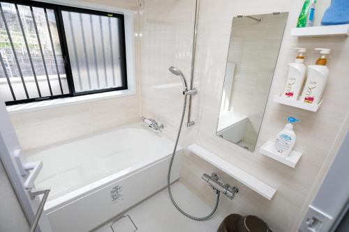 a bathroom with a shower and a tub and a sink at Gairoju / Vacation STAY 2366 in Higashi-osaka