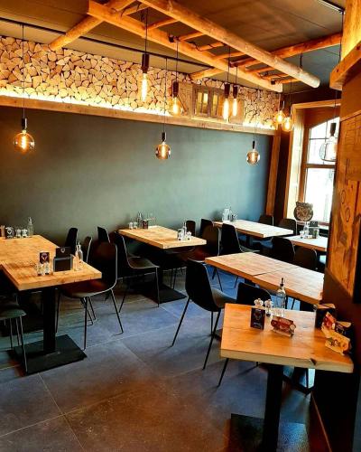a dining room with wooden tables and chairs at Renée Cense in Houffalize