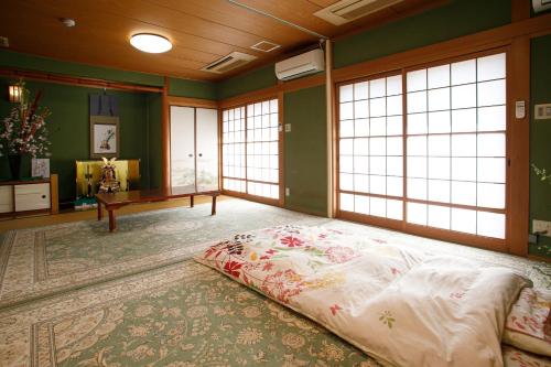 uma cama grande num quarto com janelas em Gairoju / Vacation STAY 3715 em Higashi-osaka