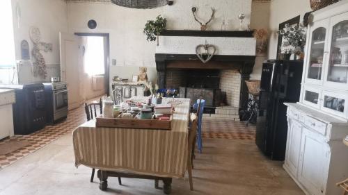 a kitchen with a table and a fireplace at B&B A la Ferme d'Ourches in Cerville