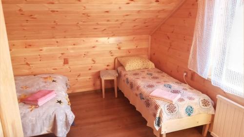 a room with two beds in a log cabin at Біля лісу Шале з двома спальнями in Slavske