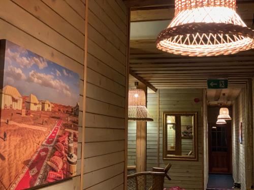 a chandelier hanging from a wall with a painting on it at Rakši in Cēsis