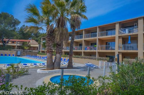 un hôtel avec un palmier et une piscine dans l'établissement Sanary sur mer, Soleil et douceur III, à Sanary-sur-Mer