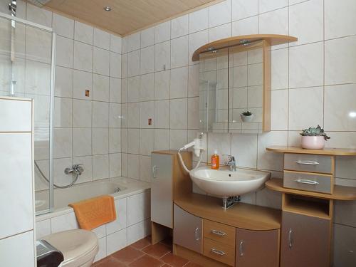 a bathroom with a sink and a toilet and a tub at Ferienwohnung Klaus im Tal der Steinach in Steinach