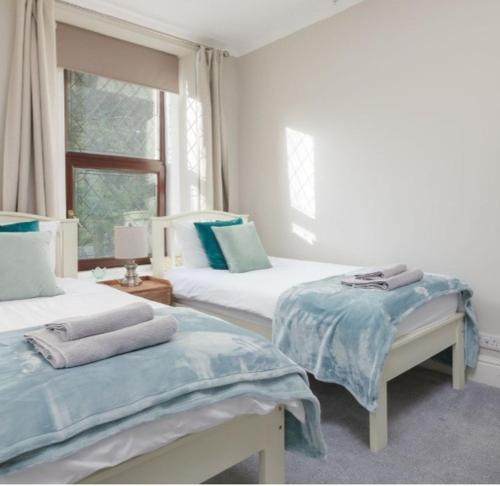 - une chambre avec 2 lits et une fenêtre dans l'établissement Gorgeous cottage by sandy beach Dog friendly, à Port Erin