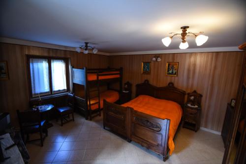 a bedroom with a bed with an orange bedspread at IL NIDO DEL FALCO in Pradleves