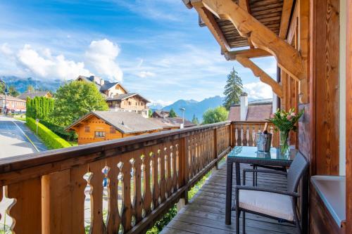 a balcony with a table and a view of the mountains at Chalet Balthazar in Villars-sur-Ollon