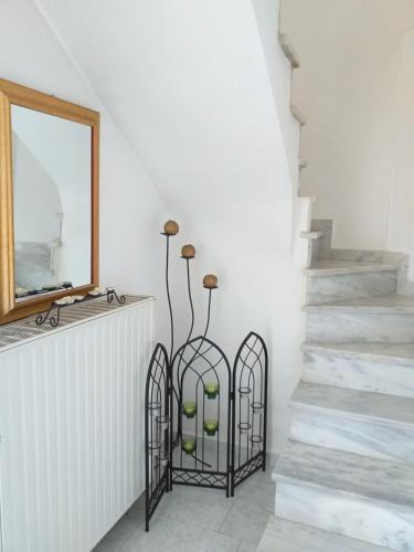 Una escalera con un espejo y dos piezas de hierro forjado en Roulas Cozy Apartments, en Artemida