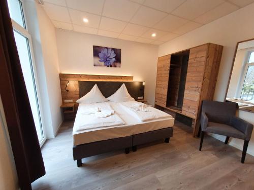 a bedroom with a bed and a chair in it at Winzerhaus Gärtner - An der Loreley in Sankt Goar