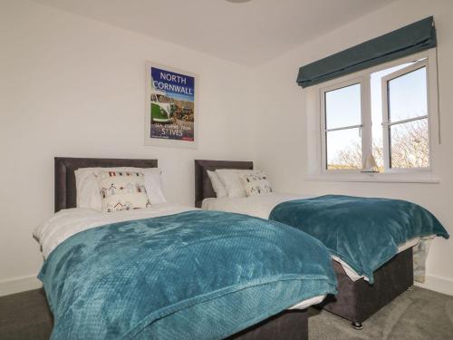 1 dormitorio con 2 camas y ventana en Trevena en Tintagel