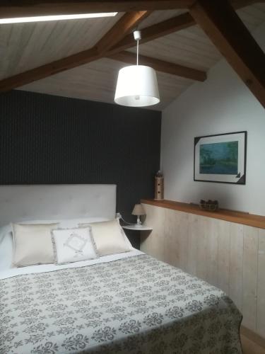 une chambre avec un lit avec un couvre-lit blanc dans l'établissement GITE JARDIN/TERRASSE COSY PRES PLAGES, à Arès