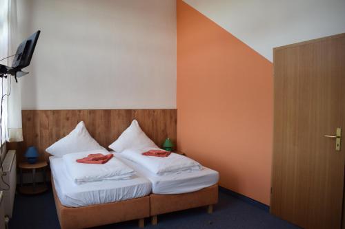ein Schlafzimmer mit einem Bett mit zwei Handtüchern darauf in der Unterkunft Pension zur Alten Schule in Kirchberg