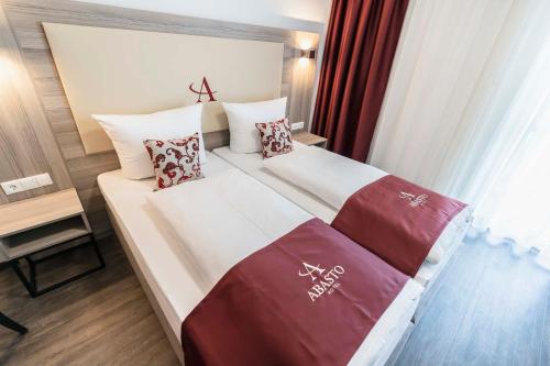 a hotel room with a bed with two pillows at Abasto Hotel München Feldmoching in Munich