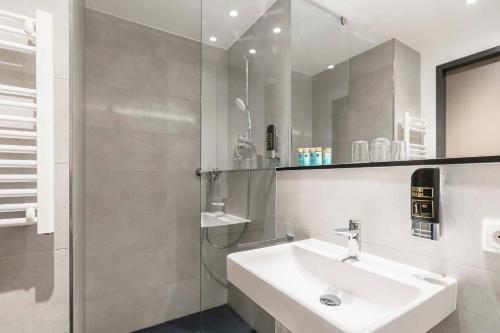 a white bathroom with a sink and a mirror at Abasto Hotel München Feldmoching in Munich