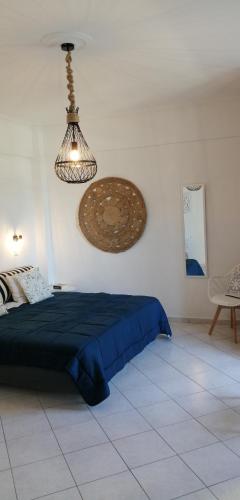 a bedroom with a blue bed and a light fixture at Santo Spiti sou 3 in Fira
