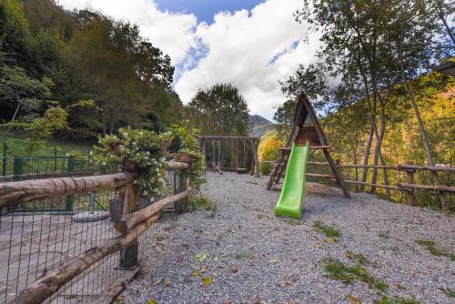 a playground with a green slide and a fence at IL NIDO DEL FALCO in Pradleves