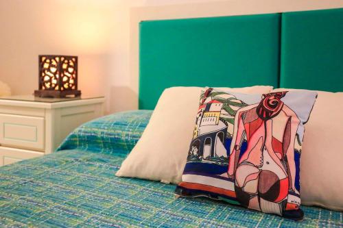 a bed with a pillow with a picture of a woman at Atrani Apartments on the Amalfi Coast, air-purified, close to the beach and easy access in Atrani