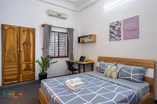 a bedroom with a bed and a desk in it at HoLo Fairy House Saigon - Serviced Homestay in Ho Chi Minh City