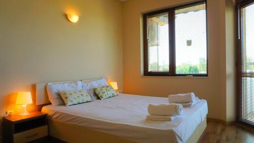 a bedroom with a bed with two towels on it at Вила Ваня - Villa Vania in Bŭlgarevo
