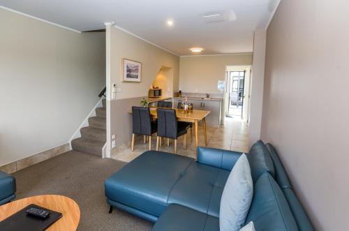 a living room with a couch and a table at Le Chalet Suisse Motel Taupo in Taupo