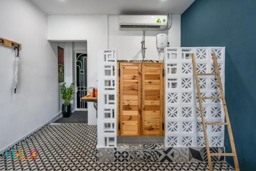 a room with a blue wall and a wooden door at HoLo Fairy House Saigon - Serviced Homestay in Ho Chi Minh City