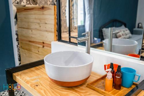 a kitchen sink with a white bowl on a wooden counter at HoLo Fairy House Saigon - Serviced Homestay in Ho Chi Minh City