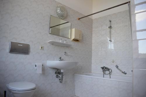 ein Badezimmer mit einem Waschbecken, einem WC und einer Badewanne in der Unterkunft Pension zur Alten Schule in Kirchberg