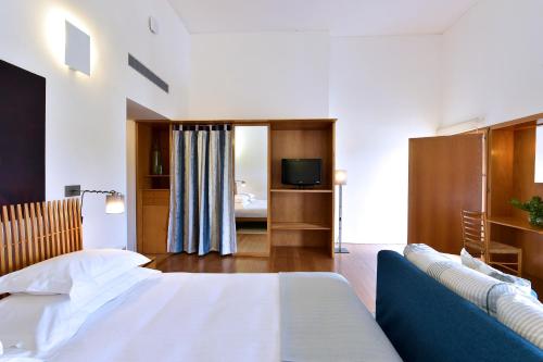 a hotel room with a bed and a television at Pousada Convento de Arraiolos in Arraiolos